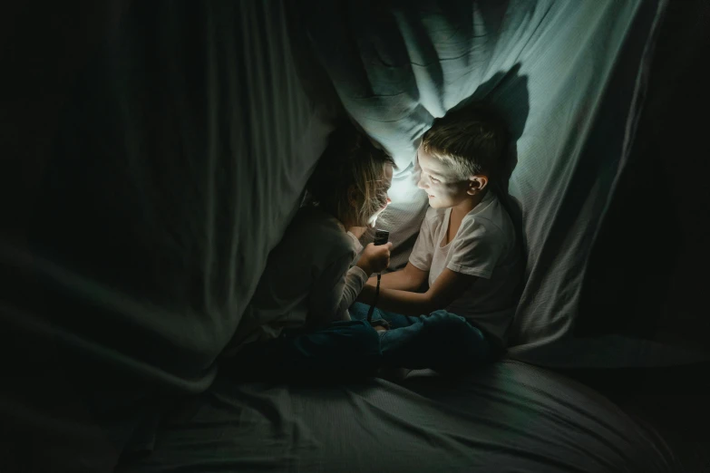 a little girl sitting on top of a bed next to a dog, by Adam Marczyński, pexels contest winner, magical realism, light over boy, small people with torches, curled up under the covers, boy and girl