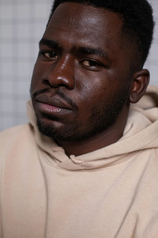 a close up of a person wearing a hoodie, inspired by Paul Georges, dark brown skin, looking confused, robust stocky body, max hay