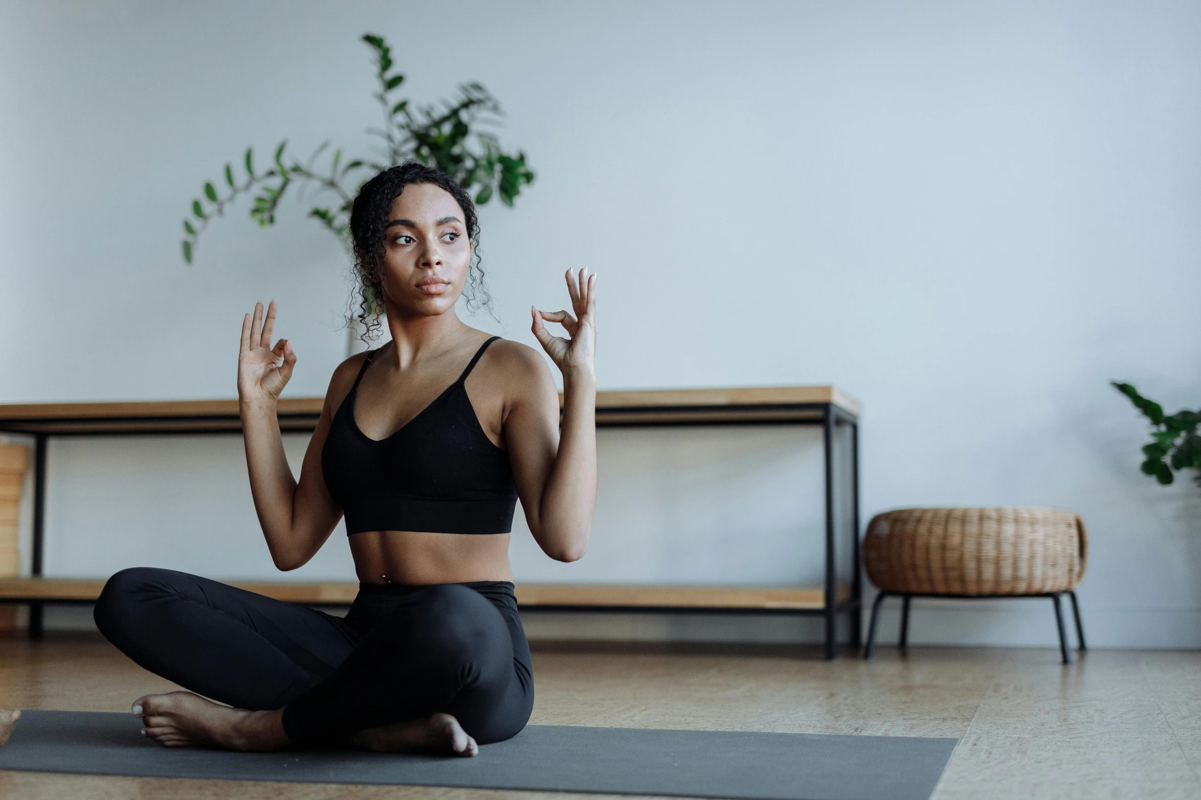 a woman sitting on a yoga mat doing a yoga pose, a portrait, unsplash, arabesque, background image, cinematic. ”, no watermarks, sitting in a lounge