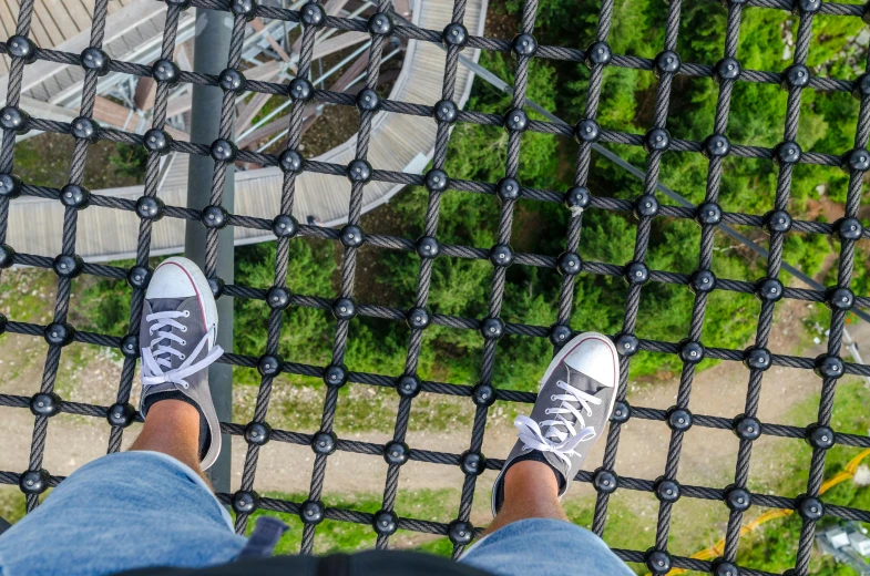 a person standing on top of a metal structure, trending on pexels, rubber waffle outsole, biodome, swings, looking down at you