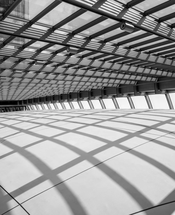 a black and white photo of the inside of a building, inspired by Zaha Hadid, unsplash contest winner, light and space, square lines, in future airport rooftop, long shadows, santiago calatrava