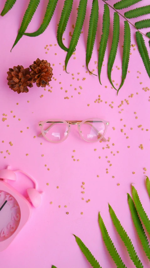 a pink alarm clock sitting on top of a pink table, inspired by Wes Anderson, trending on pexels, plants in glasses, scattered golden flakes, 8k octan photo, square rimmed glasses