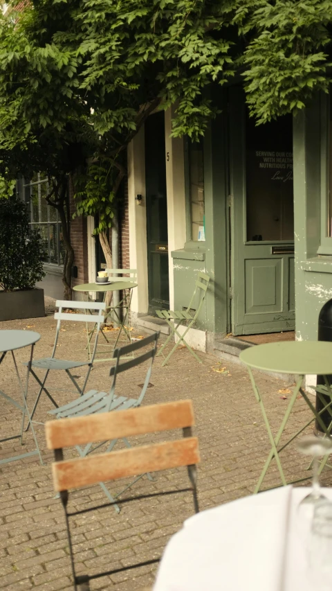 a table and chairs outside of a restaurant, by Jan Tengnagel, happening, sage green, amsterdam, caparisons, thumbnail