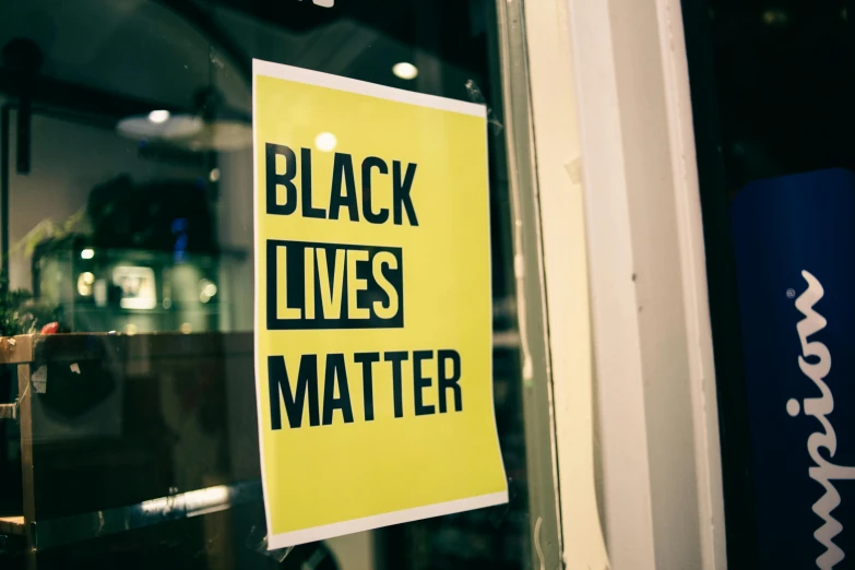 a black lives matter sign in a store window, black arts movement, black. yellow, profile image