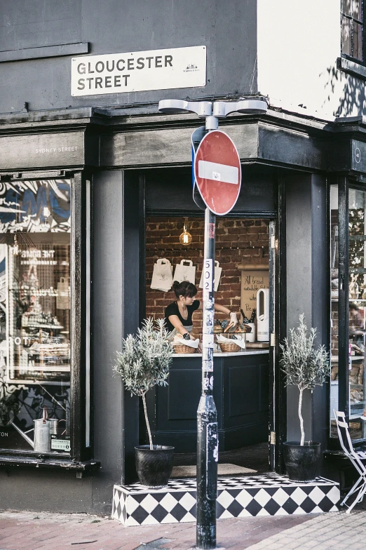 a red stop sign sitting on the side of a street, trending on unsplash, private press, stood outside a corner shop, at the counter, wearing a french beret, sitting on a store shelf