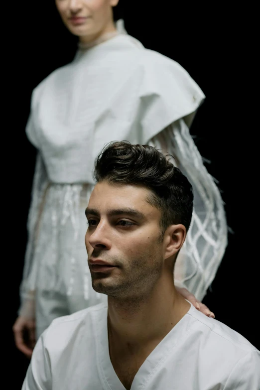 a man and a woman standing next to each other, an album cover, inspired by Giovanni Lanfranco, pexels contest winner, wearing white cloths, portrait of a young man, arca album cover, intricate clothes