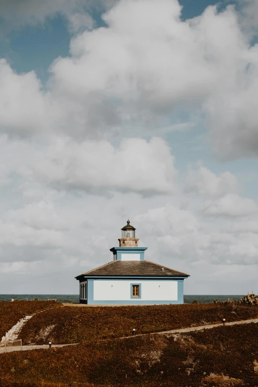 a small light house sitting on top of a hill, square, light blue sky, hexadome, pablo olivera