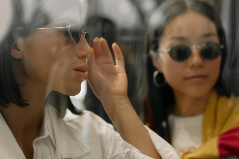 a woman looking at her reflection in a mirror, trending on pexels, hyperrealism, wearing 3 d glasses, asian women, reaching out to each other, people shopping