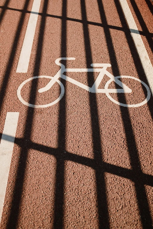 a bike lane with a bicycle painted on it, unsplash, square lines, detailed shadows, floor grills, promo image