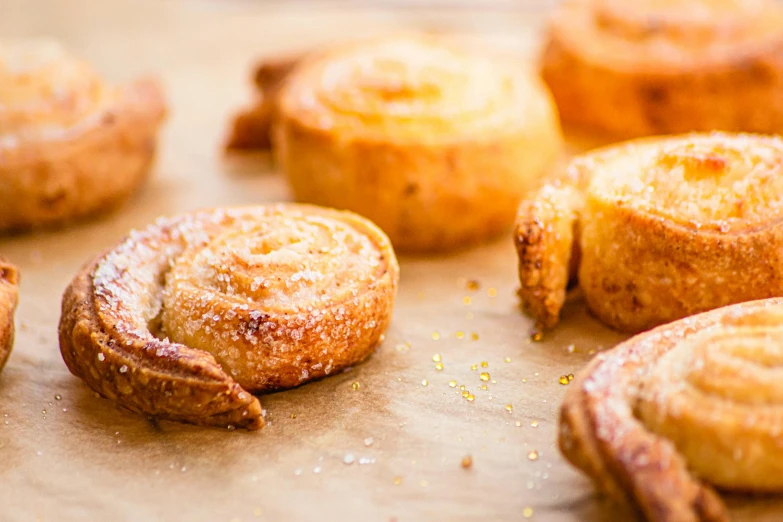 a bunch of pastries sitting on top of a table, by Sylvia Wishart, unsplash, golden spirals, sugar sprinkled, from the elbow, scandinavian