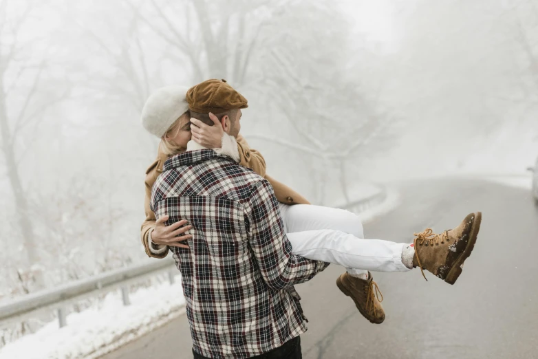 a man carrying a woman on his back on a snowy road, pexels contest winner, foggy day outside, flirting, white, thumbnail