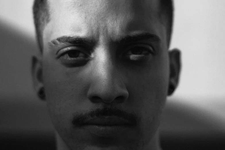 a black and white photo of a man with a mustache, a black and white photo, inspired by Alexis Grimou, pexels, pete davidson, violence in his eyes, color photograph portrait 4k, square masculine facial features