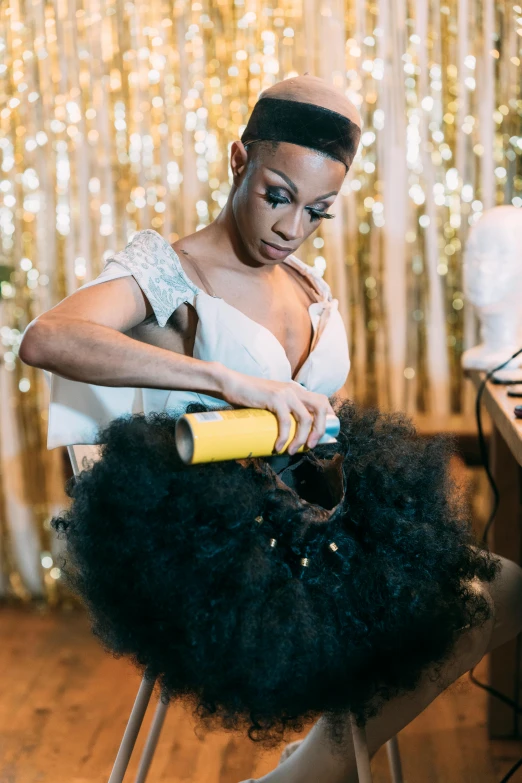 a woman sitting in a chair using a blow dryer, black arts movement, wearing a tutu, holding a gold bag, glittery short black hair, thumbnail