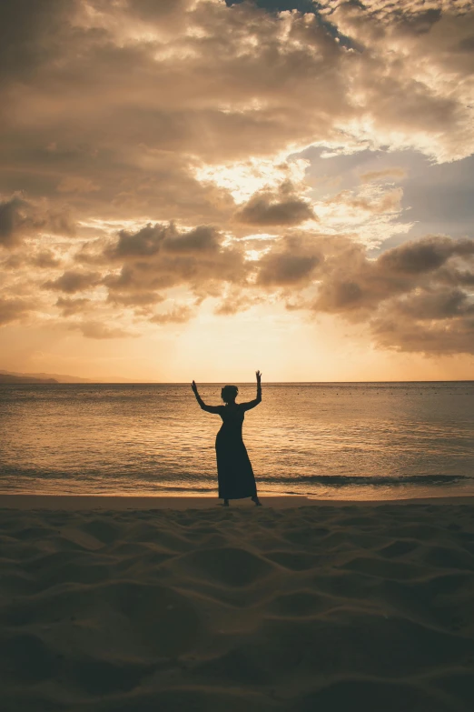 a person standing on a beach with their arms in the air, golden hour in boracay, “ femme on a galactic shore, praying, high-quality photo