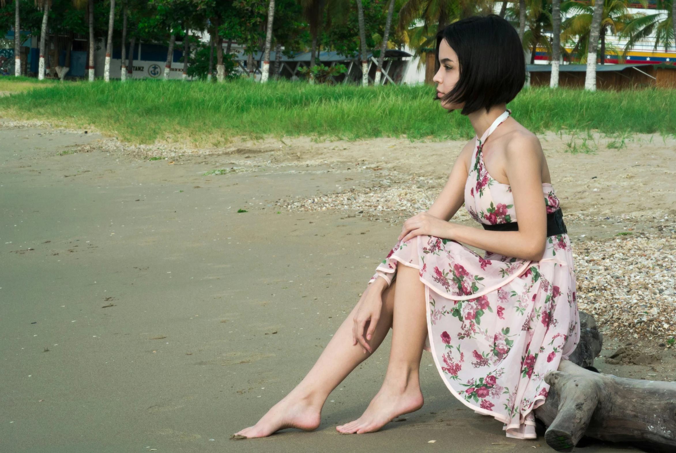 a woman sitting on a log on the beach, a portrait, inspired by Amelia Peláez, pexels contest winner, romanticism, dressed in a flower dress, kiko mizuhara, thoughtful ), pink