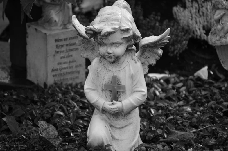 a black and white photo of a statue of an angel, a statue, adorable, graves, childlike, dressed in ornate