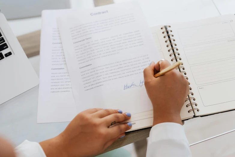 a woman sitting at a desk writing in a notebook, an album cover, by Carey Morris, pexels contest winner, medical reference, holding it out to the camera, white paper, background image