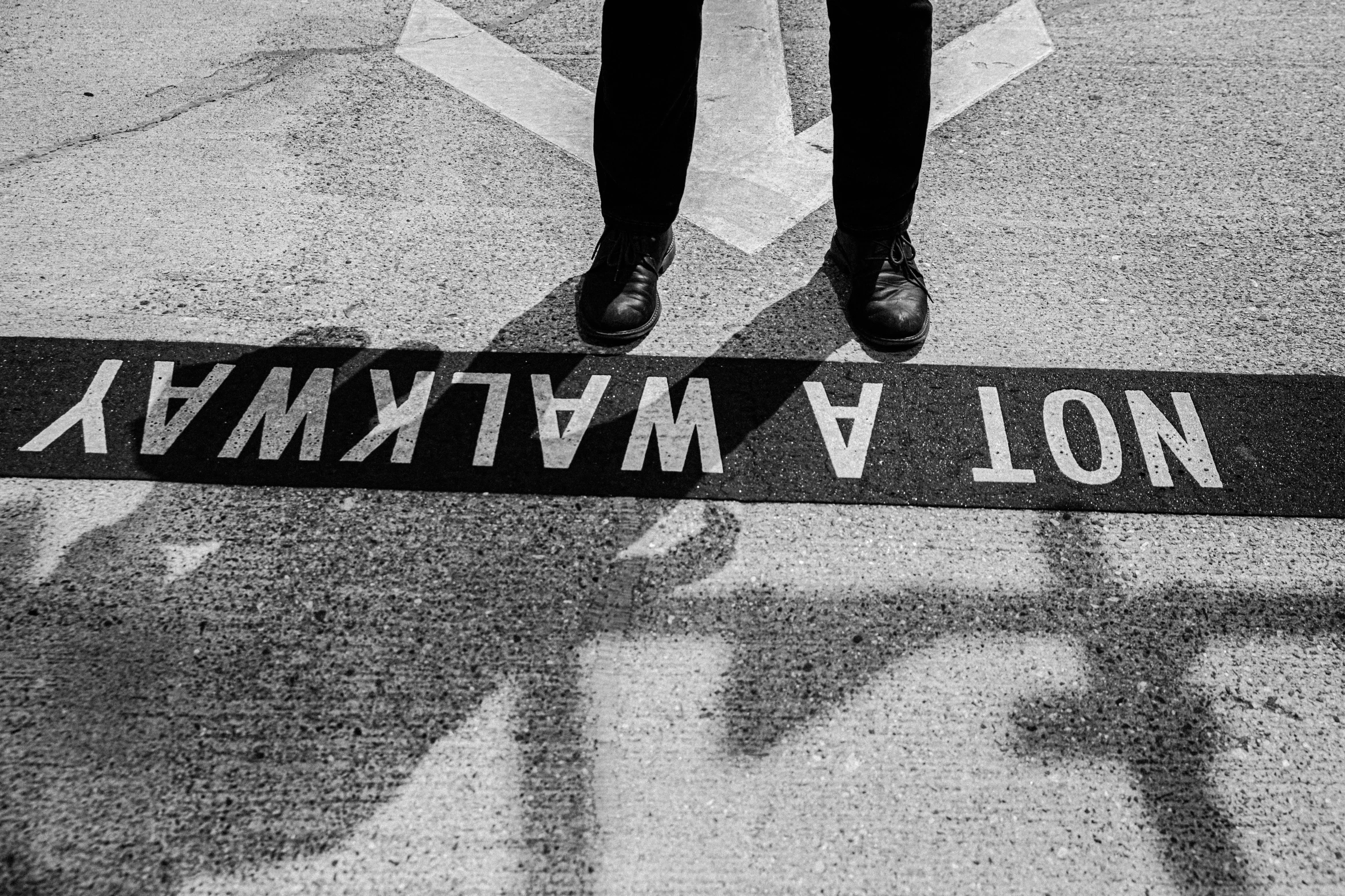 a black and white photo of a person standing on a street, inspired by Vivian Maier, unsplash, welcome to the matrix, born under a bad sign, detailed conceptual photography, with infinity