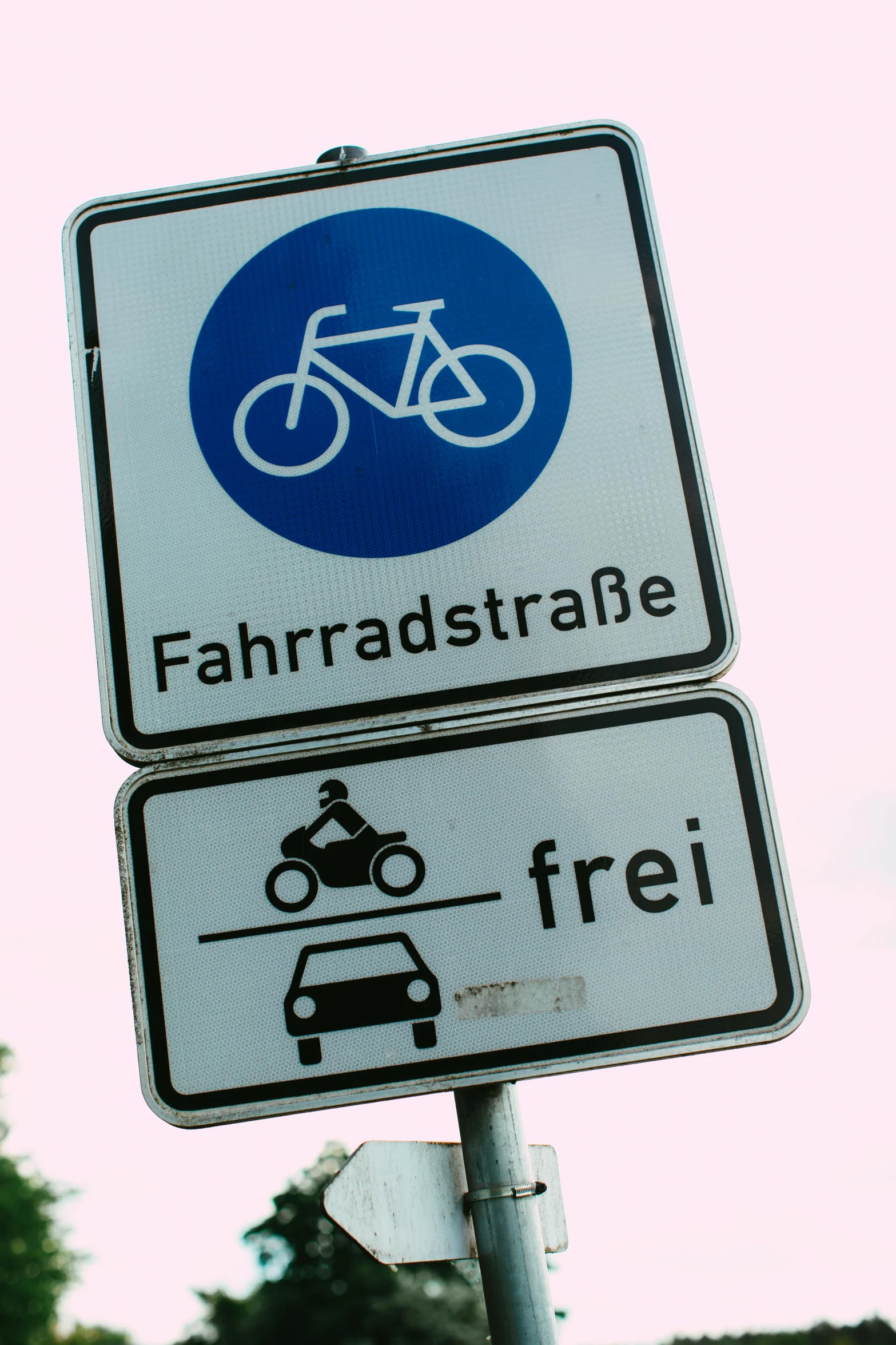 a close up of a street sign with trees in the background, a poster, by Hans Schwarz, unsplash, bauhaus, rides a bike, a fat, car traffic, with an intricate