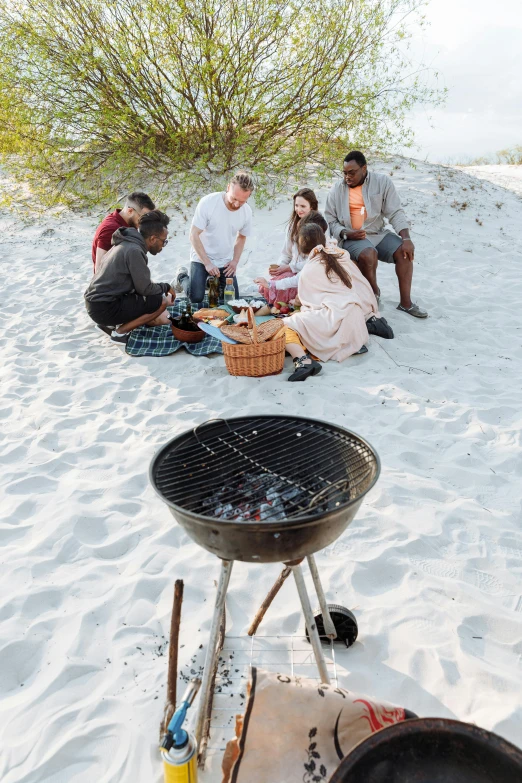 a group of people sitting on top of a sandy beach, grill, beach on the outer rim, riding, woodfired