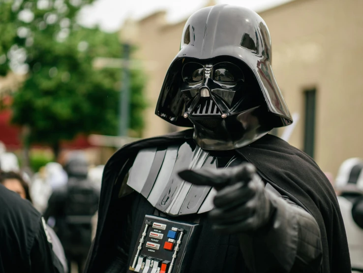 a man dressed in a darth vader costume, unsplash, with pointing finger, candid shot, tie fighters, ned kelly