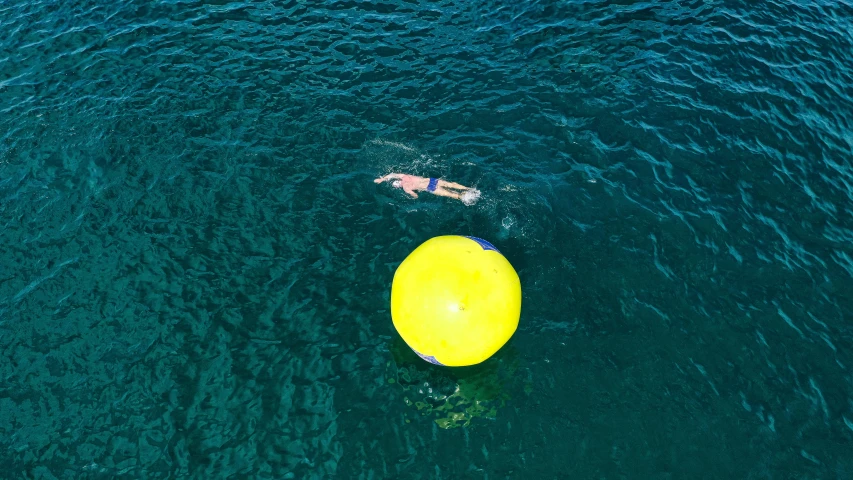 a yellow balloon floating on top of a body of water, manly, people swimming, a high angle shot, 3 meters