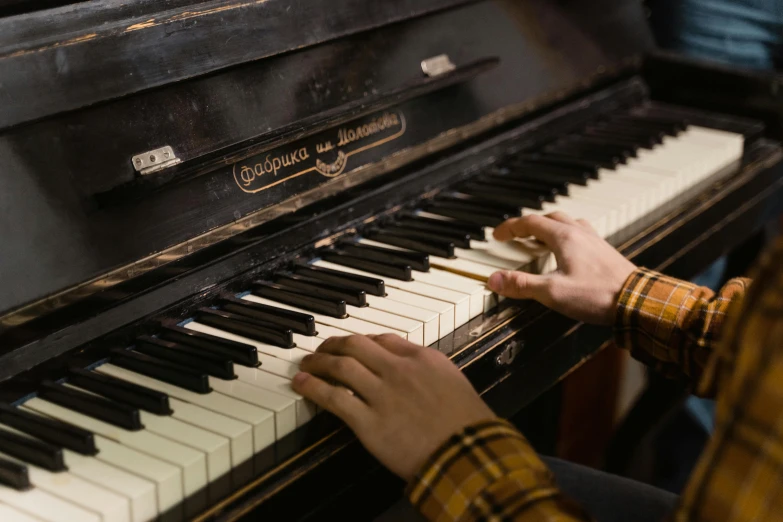 a close up of a person playing a piano, by Elsa Bleda, fan favorite, brown, worn, schools