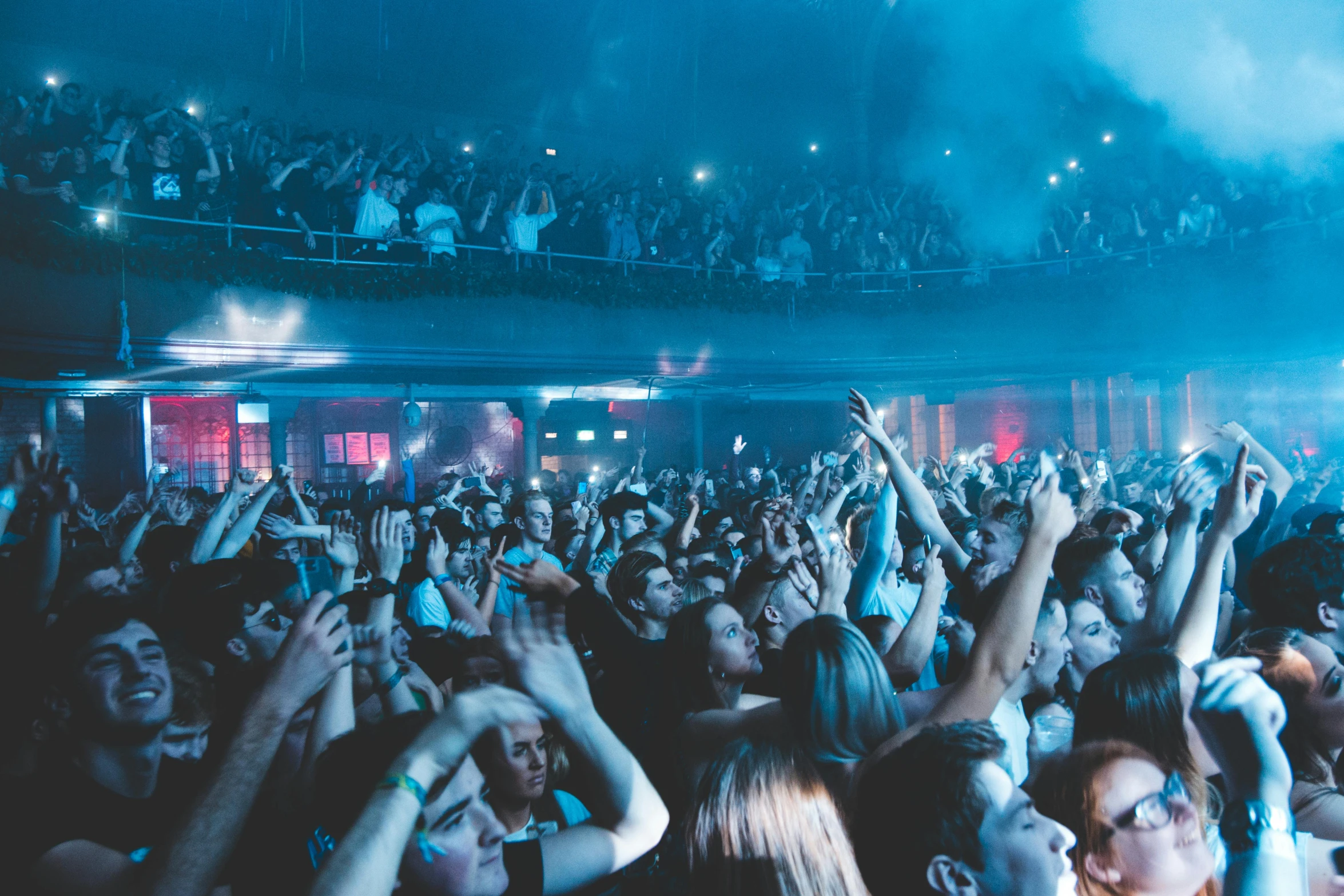 a crowd of people at a concert with their hands in the air, pexels contest winner, happening, hull is a opera house, blue neon, photograph of three ravers, completely empty