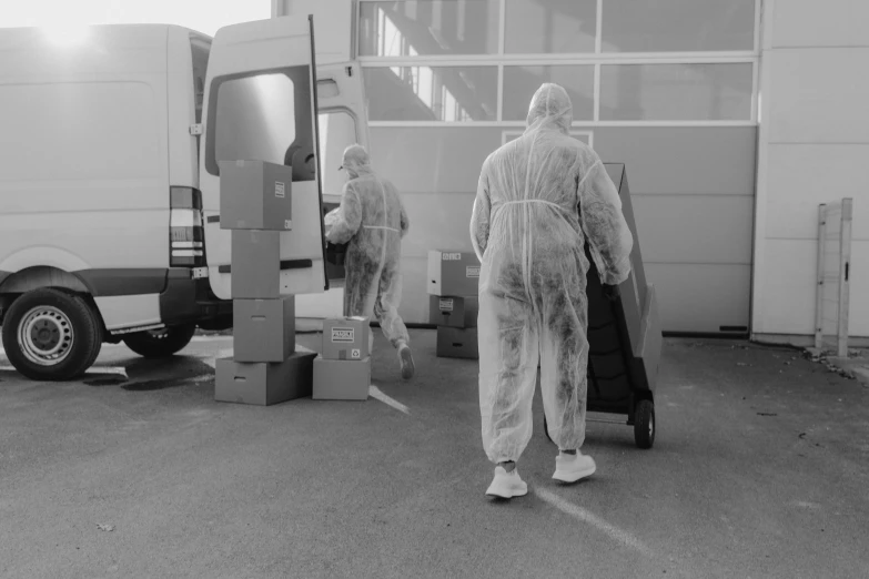 a couple of people that are standing in front of a van, a black and white photo, pexels, process art, staff wearing hazmat suits, delivering parsel box, manufacturing, faceless people