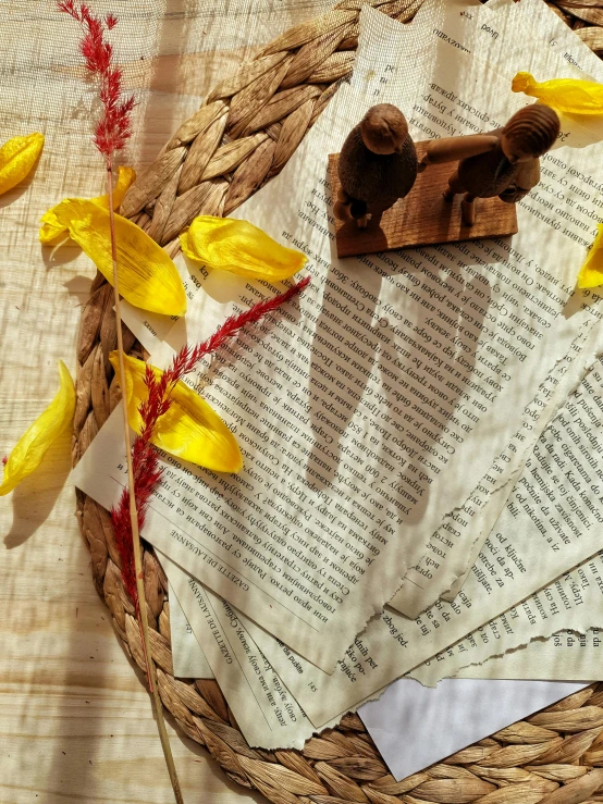 a basket filled with yellow flowers sitting on top of a table, by Isabel Naftel, pexels contest winner, private press, indian script, detail shots, layered paper, wooden statue