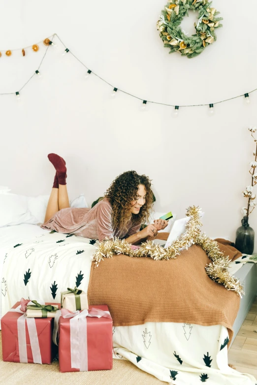 a woman laying on a bed reading a book, a photo, trending on pexels, happening, wearing festive clothing, curls, hight decorated, gif