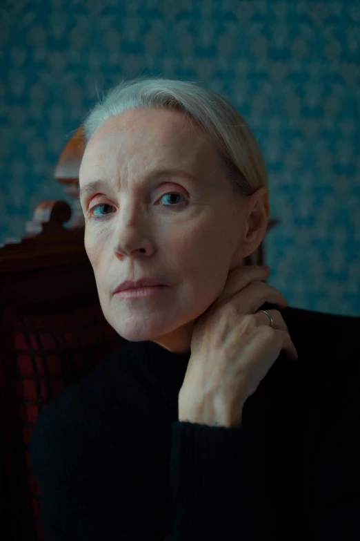 a woman sitting in a chair with her hand on her chin, film still promotional image, pale complexion, 5 5 yo, ingmar bergman