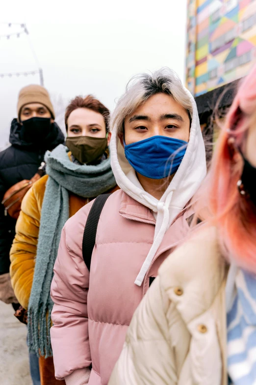 a group of people walking down a street wearing face masks, trending on pexels, extreme cold, non-binary, instagram picture, multicolored