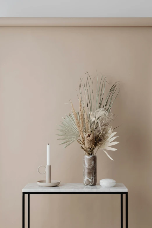 a table with a vase and a candle on it, trending on unsplash, minimalism, beige color scheme, palm, mixed art, large tall