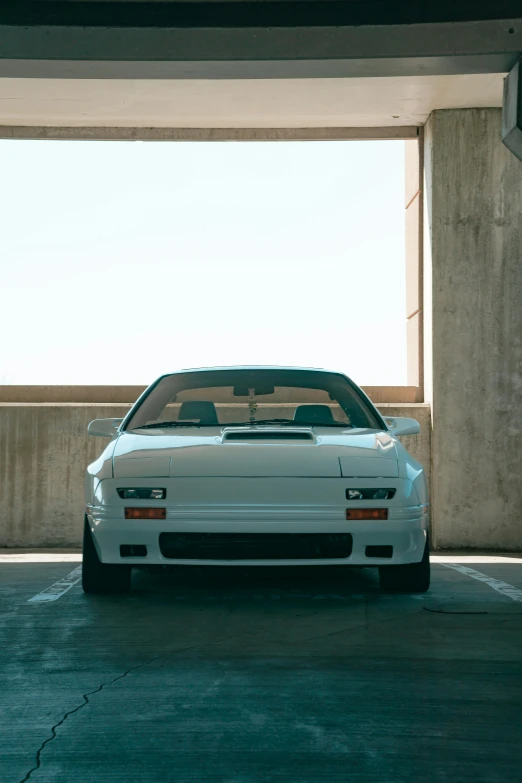 a white car parked in a parking garage, inspired by Zhu Da, unsplash, renaissance, 1985 vector w8 twin turbo, iroc, soft color dodge, exterior shot