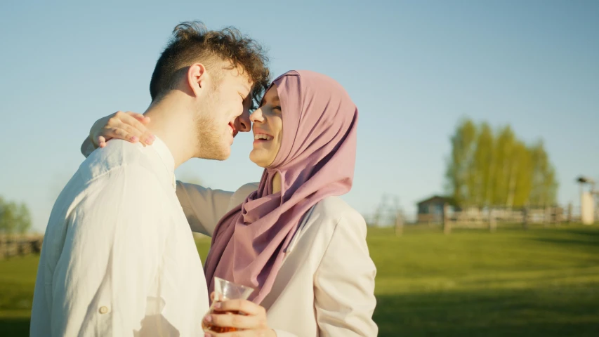 a man and a woman standing next to each other, a picture, shutterstock, hurufiyya, licking, at a park, official screenshot, high forehead