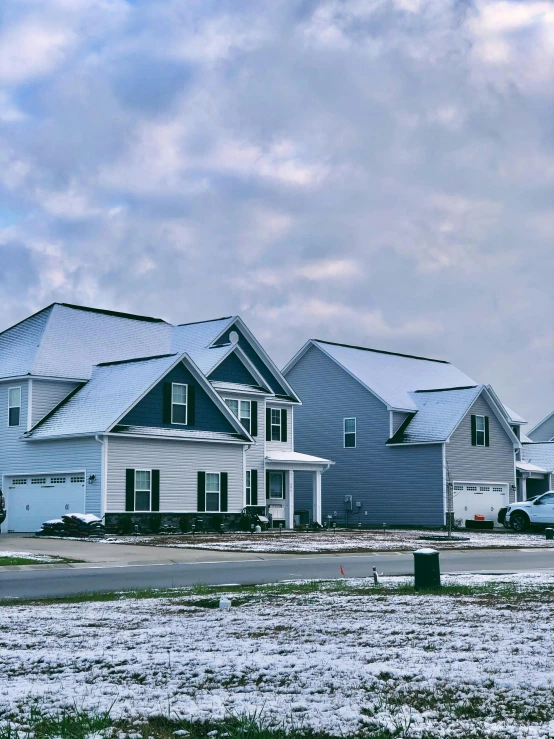 a row of houses with snow on the ground, a colorized photo, by Carey Morris, pexels contest winner, gray skies, subdivision, construction, profile image