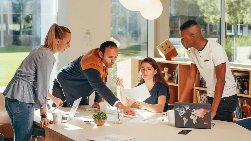 a group of people standing around a table, designer product, thumbnail