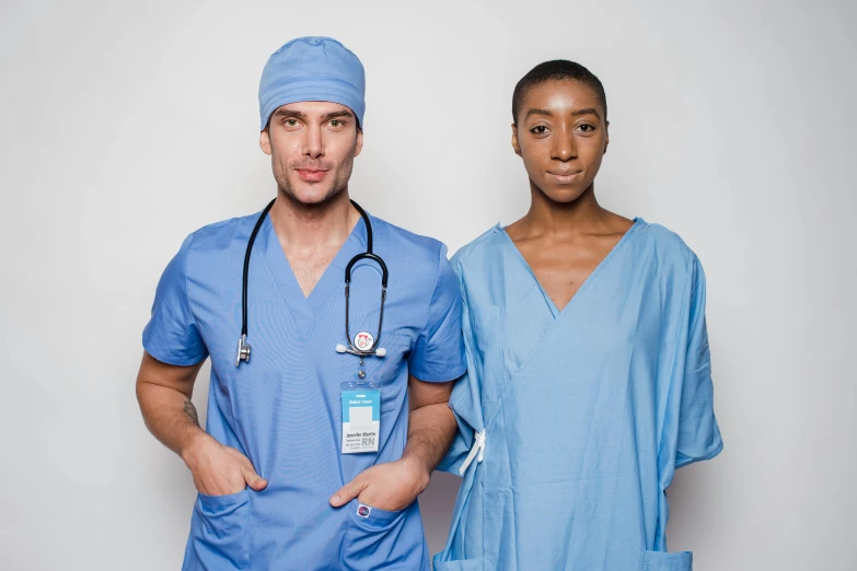 a couple of doctors standing next to each other, pexels contest winner, renaissance, light blue skin, nurse scrubs, ( ( dark skin ) ), grey