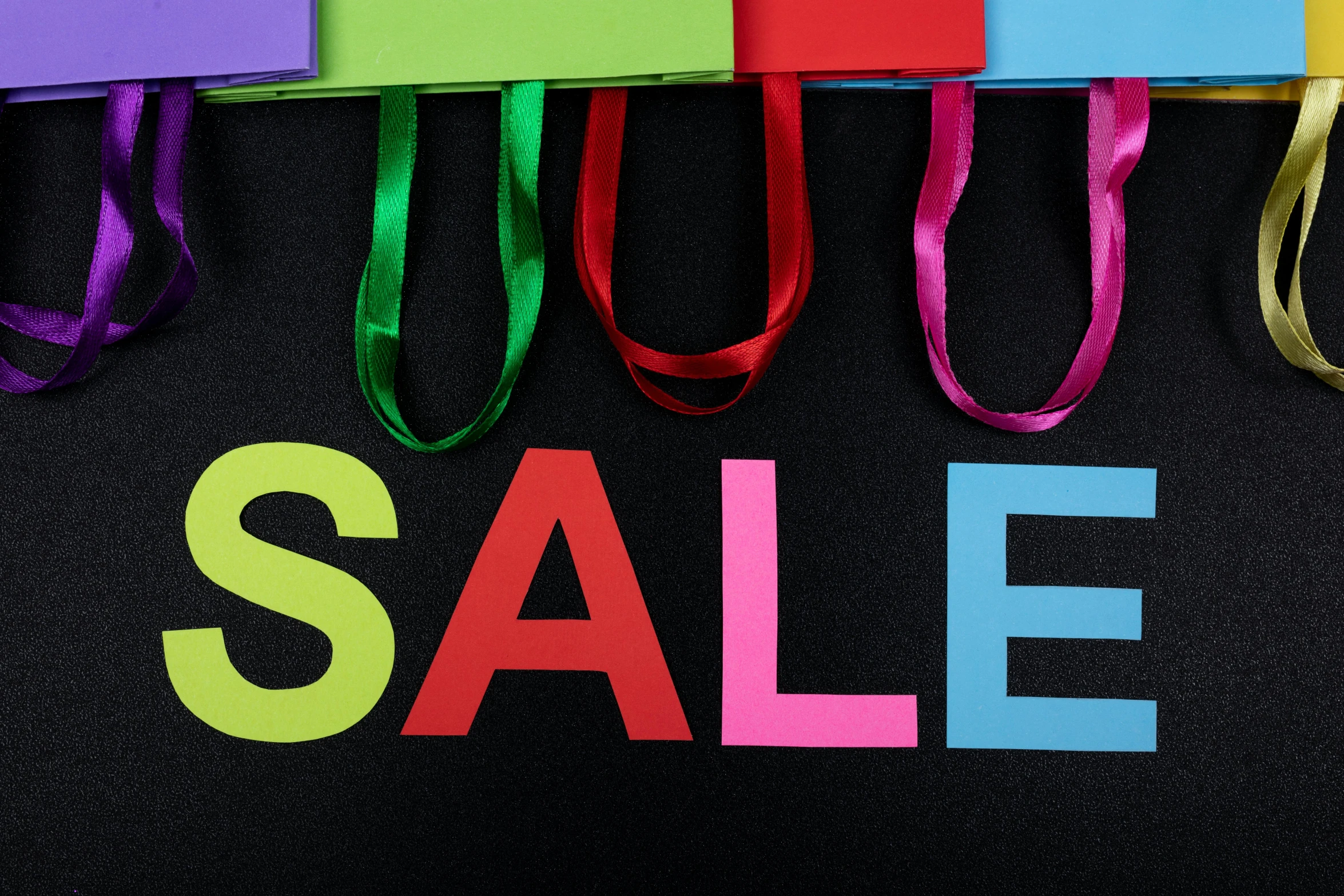 a colorful sale sign on a black background, a photo, by Julia Pishtar, shutterstock, bags on ground, square, brand colours are green and blue, kyza saleem