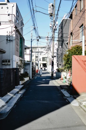 a street filled with lots of tall buildings, by Miyamoto, unsplash, mingei, shady alleys, suburbia street, sunny day time, ruins around