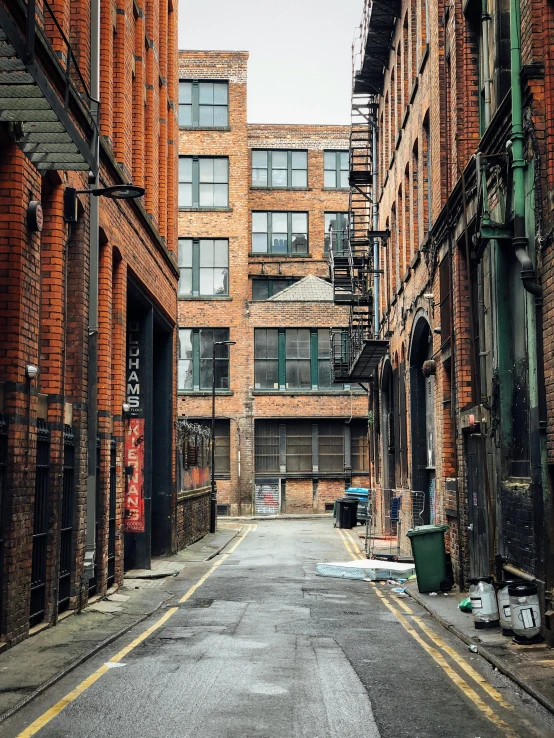 a city street lined with tall red brick buildings, inspired by Thomas Struth, pexels contest winner, street art, “derelict architecture buildings, costumes from peaky blinders, high detail photo of a deserted, former