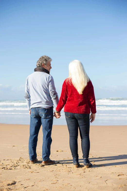 a man and a woman holding hands on a beach, bushy white beard, profile image, single subject, facing away