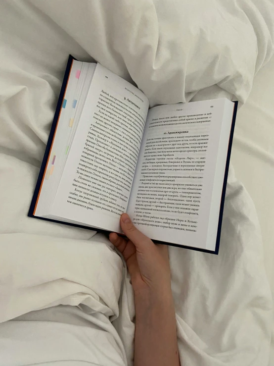 a person laying in bed reading a book, detailed information, low quality photo, jovana rikalo, very accurate photo