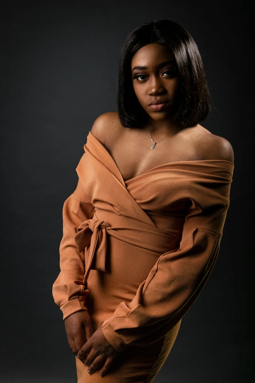 a woman in an orange dress posing for a picture, an album cover, trending on pexels, dark brown skin, studio!! portrait lighting, brown sweater, portrait of maci holloway