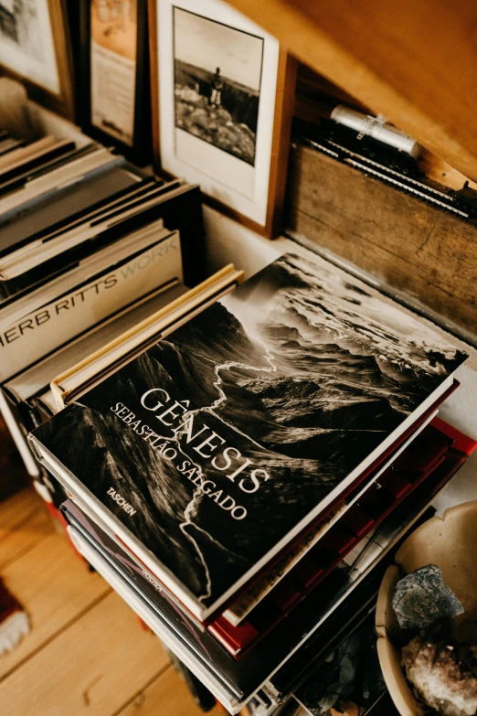 a pile of books sitting on top of a wooden shelf, poster art, by Ejnar Nielsen, unsplash contest winner, detailed photo of an album cover, sebastiao salgado, wide high angle view, metal album cover art