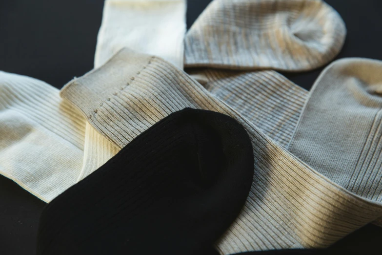 a pile of socks sitting on top of a table, by David Simpson, unsplash, renaissance, silver，ivory, black textured, organic detail, detail shot