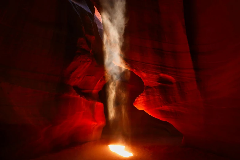 a close up of a fire with smoke coming out of it, by Randall Schmit, pexels contest winner, antelope canyon, red glow, inside a cavernous stomach, moonlight shafts