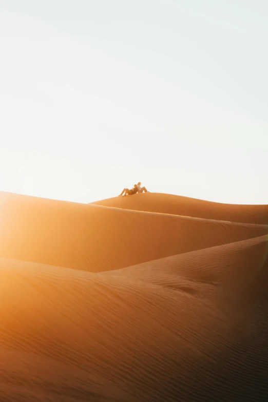 a person riding a motorcycle in the desert, unsplash contest winner, minimalism, sun lit, moroccan, buried in sand, golden hour 4k