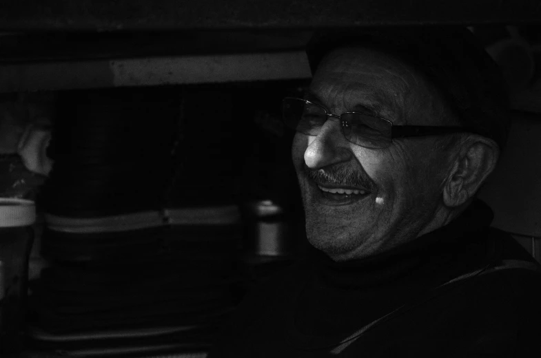 a black and white photo of a man smiling, by Jan Konůpek, pexels contest winner, old charismatic mechanic, low-key, giulio rosati, happy smile